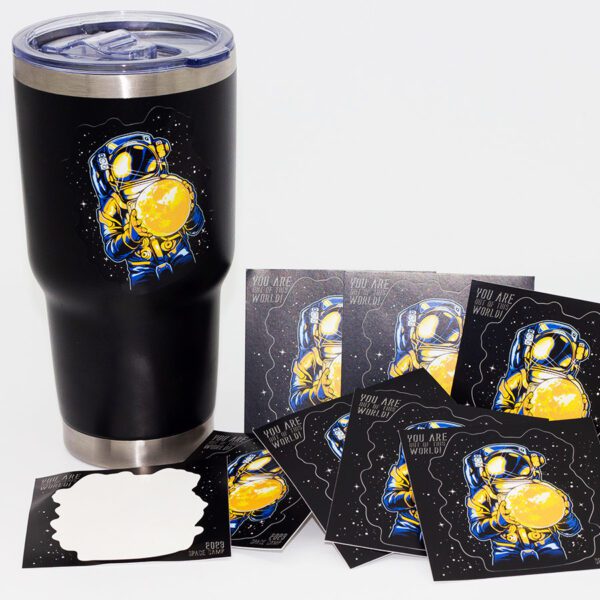 Black tumbler adorned with kiss cut vinyl stickers and various colorful designs.